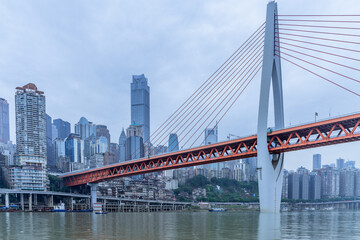 Panorama view of the Qiansimen bridge and skyline in Chongqing, China, on a cloudy day.