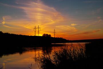 Sunset over a wide lake. Lake and forest on the far shore during sunset