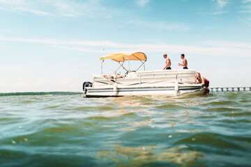 Friends hanging out on a pontoon boat in the ocean