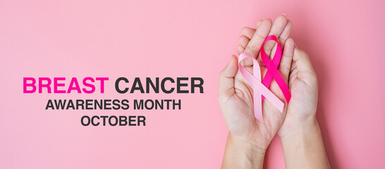 October Breast Cancer Awareness month, adult Woman hand holding Pink Ribbon on pink background for supporting people living and illness. International Women, Mother and World cancer day concept