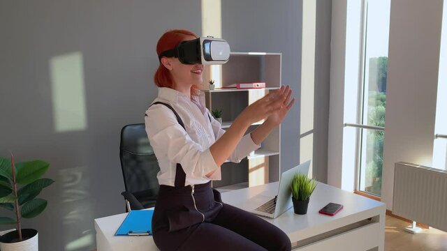 Business woman wearing VR goggles and interacts with cyberspace
