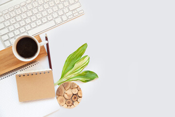 Office table top. Workspace with blank board with clip, keyboard, stationery, pencil, coffee cups on light gray background. Place for text