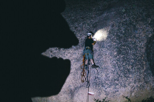 Shadow of a huge monster threatening a climber that&Ocirc;&oslash;&Omega;_s climbing a wall at night