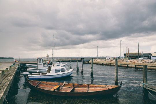 Old wooden boat anchored in a small harbour on a stormy day
