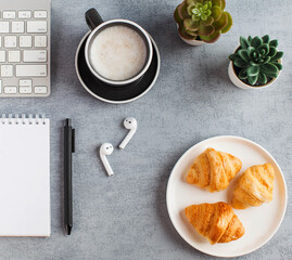 White Notepad, wireless headphones, coffee mug. The concept of online training, work from home, home office. Copy space.