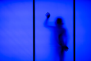Silhouette of a woman behind the glass