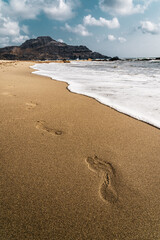 Fußabdrücke in nassem Sand am Meer