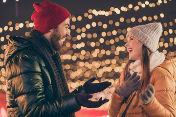 Photo of two friends guy speaking with girl on x-mas party under evening tradition illumination...