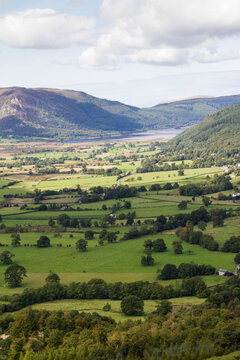 Valley view of patchwork fields with mountains behind