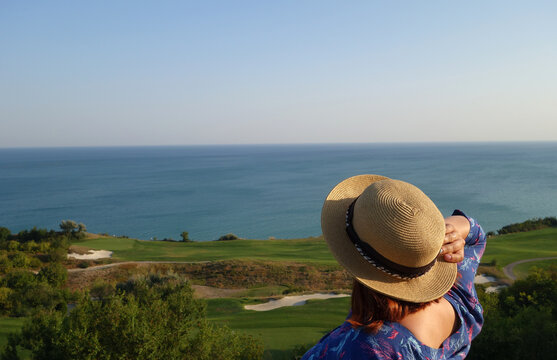 Girl In Straw Hat Looking At Golf Filed And Sea.