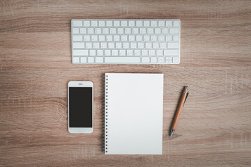 Top view of office desk with notebook and keyboard.