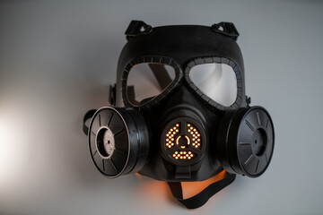 black gas mask with orange light