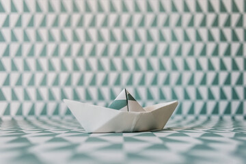 Origami boat on wallpaper background