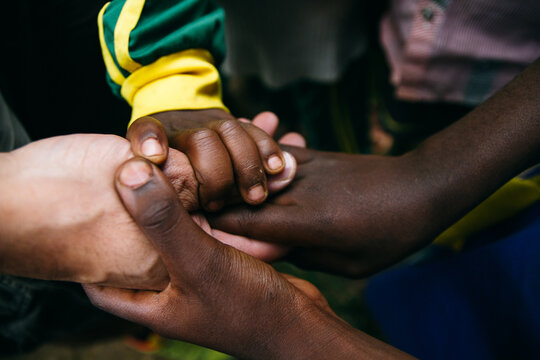 Multiethnic Hands Together Of A Man And Children In Africa School