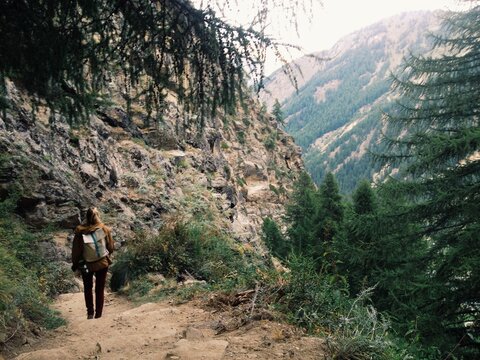 Woman walking down a path in the mountains.