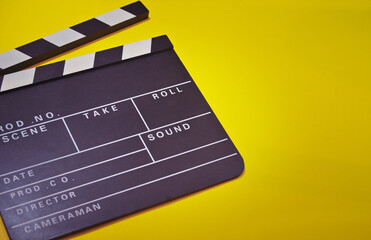 Fototapeta na wymiar Flat lay an open film clap board with a bright yellow background. A movies concept
