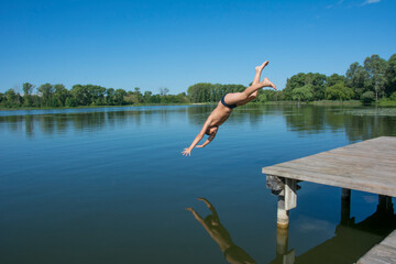 On a hot summer day, the boy dives into the river.