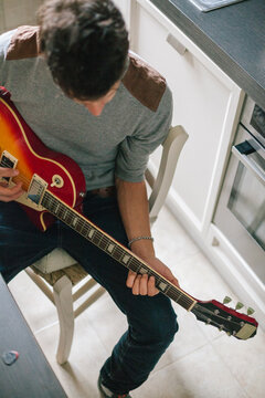 Young man playing the guitar at home