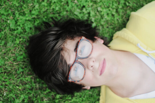 A young man lays in the grass