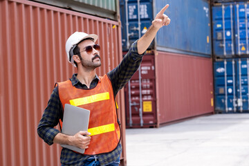 A confident engineer or technician wears a white helmet and holding laptop. Standing at the...