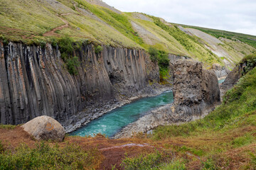Breathtaking view of Studlagil canyon in Jokuldalur Valley in Iceland. Basalt columns and turquoise glacier river.