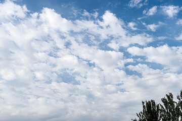 White fluffy clouds in a blue sky, background and pattern