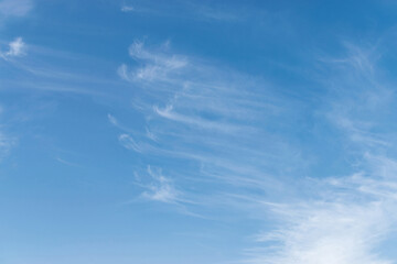 White cirrus clouds on a blue sky, background and pattern
