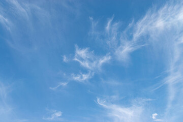 White cirrus clouds on a blue sky, background and pattern