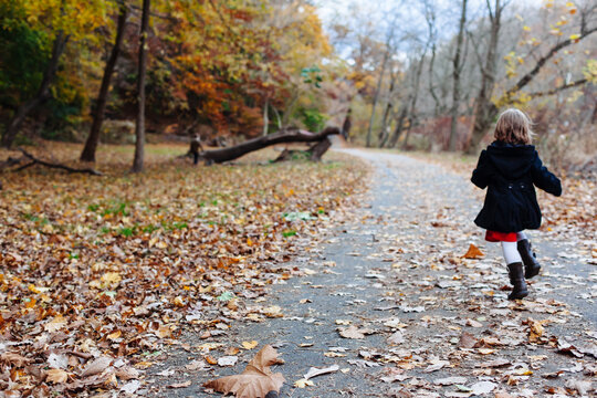 Girl runs down path in fall