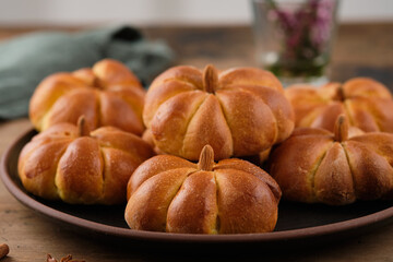 Pumpkin buns bread with spices on brown background. Halloween Food Concept. Autumn concept.