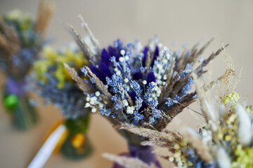 Bouquet of dried, colored flowers on a beige background. Place for text and design. Greeting card. Flowers composition.
