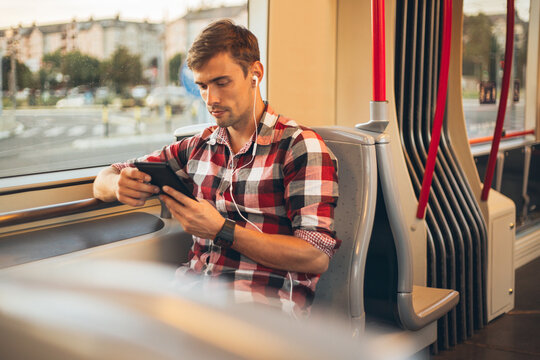 Man reading an e book in a tram