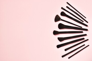 Set of makeup brushes on a pink background. Copy space, flat lay. Beauty concept, beauty industry