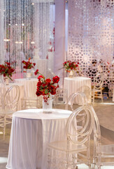 luxury wedding decor with flowers and glass vases and number of setting on round tables