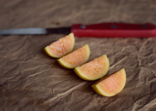 Cut open guava fruit with light peach pulp and seeds
