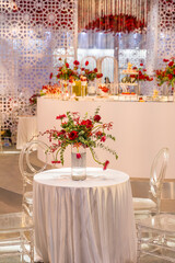 luxury wedding decor with flowers and glass vases and number of setting on round tables