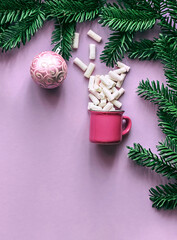Branches of a Christmas tree with Christmas decorations on a lavender background. Template for a greeting card or design.