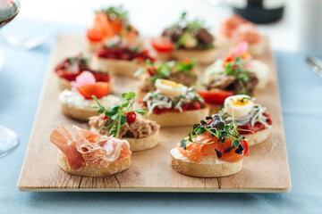 Side view on assorted tapas with different toppings