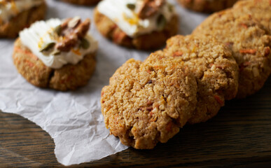 Keto Carrot oatmeal cookies. Healthy homemade ketogenic diet dessert decorated with white cream, nut and seeds. set on white cafe table background.