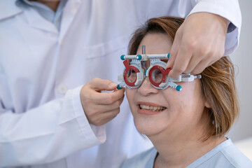 Optometrist with trial frame checking Senior Asian woman patient vision