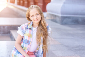 Beautiful american portrait of schoolgirl. Preschool kid. Little happy girl outdoors. Pretty female person. Adorable candid children. Near building. Staycation smile