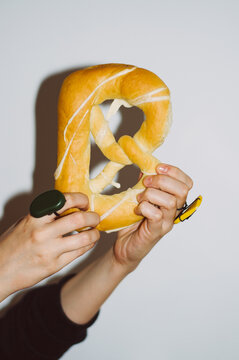Hands holding pretzel in shape of letter B