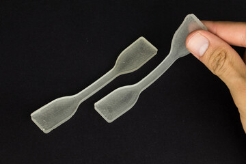 polydimethylsiloxane (pdms) polymer sample which is using in engineering experiments. it is a tensile test specimen to examine the strength of the material.