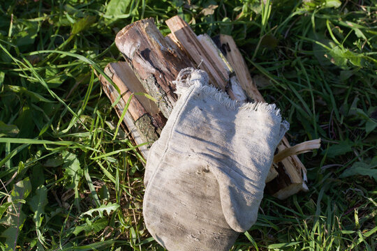 Grill Firewood. Grilling Mittens Lie On Top Of The Wood. Close-up Shot.