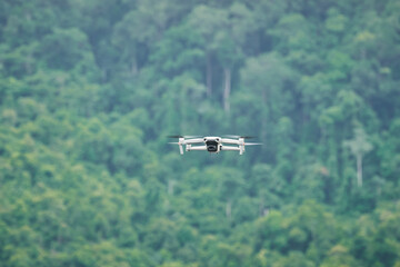 Fototapeta na wymiar Single drone fly in forest background