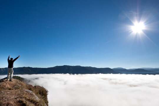 Man cheering on the top of a mountain