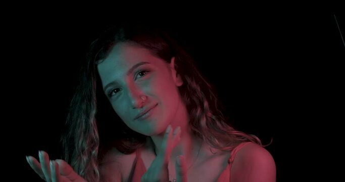 Beautiful young woman is dancing in party. Neon, blue and red light in studio shot, club and music with girl concept. Multicolored skin, ultraviolet light.