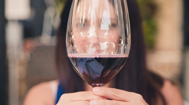 woman drinking a large glass of red wine outside in a garden backyard  stock photo royalty free 