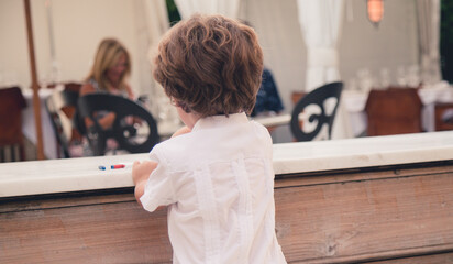 boy child feeding coy fish in a fountain in 