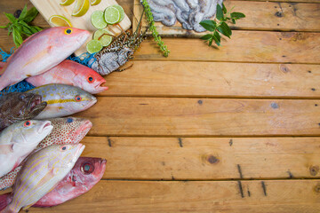Seafood: fresh tropical fishes, lobster and octopus on wooden table. Ingredients from Venezuela in...